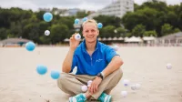 Transport autonomiczny i bezzałogowy | Studia I stopnia w Gdyni | Uniwersytet WSB Merito Gdynia: Student na plaży w Gdyni z piłęczką Merito w dłoni