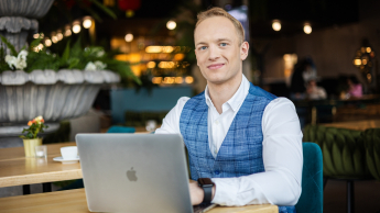 Bezpieczeństwo systemów informatycznych | Studia I stopnia w Gdyni | Uniwersytet WSB Merito Gdynia: Student w biznesowym stroju w kawiarni przy laptopie