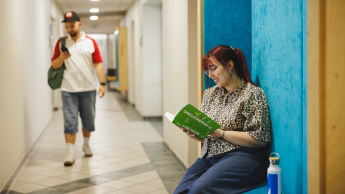 Finanse i rachunkowość - studia 3-semestralne | Studia II stopnia w Gdyni | Uniwersytet WSB Merito Gdynia: Student idzie przez korytarz w budynku Uniwersytetu w Gdyni