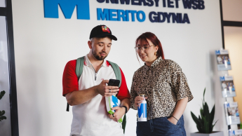 Poznaj nas | Uniwersytet WSB Merito Gdynia: Student i studentka w holu Uniwersytetu WSB Merito Gdynia