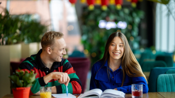 Prompting i optymalizacja systemów AI | Studia I stopnia w Gdyni | Uniwersytet WSB Merito Gdynia: Student i studentka nad książką