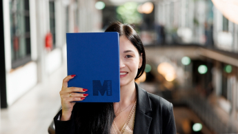 AI Product Manager | Studia podyplomowe w Gdyni | Uniwersytet WSB Merito Gdynia: Słuchaczka z notatnikiem z sygnetem M