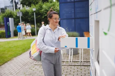 Nasz budynek | Uniwersytet WSB Merito Gdynia: Studentka wyjmuje książki z książkomatu