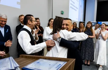 Aktualności | Uniwersytet WSB Merito Gdynia: Fotografia reporterska z wydarzenia rozdania dyplomów po ukończeniu studiów podyplomowych przedstawiająca uścisk absolwenta z opiekunem kierunku 