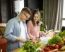 Uniwersytety WSB Merito na Impact26 | Aktualności | Uniwersytet WSB Merito Gdynia: Student i studentka nad książką, wokół warzywa i owoce