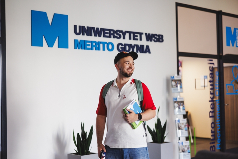 Nowoczesne przywództwo w biznesie | Studia podyplomowe w Gdyni | Uniwersytet WSB Merito Gdynia: Student przed wejściem do Biura Rekrutacji