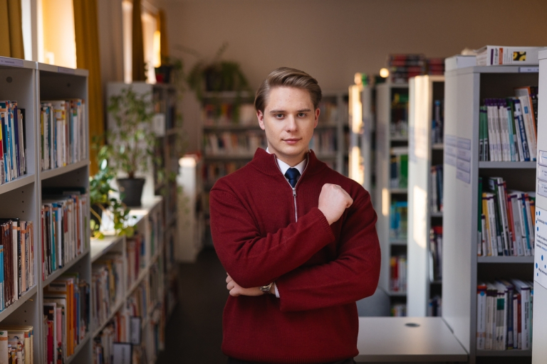 Nutripsychiatria | Studia podyplomowe w Gdyni | Uniwersytet WSB Merito Gdynia: Student w bibliotece w swetrze, a pod spodem w koszuli