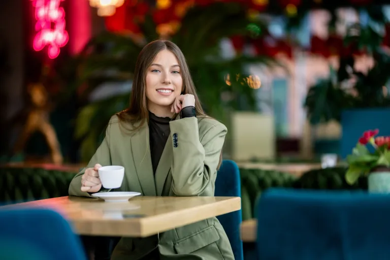 Zarządzanie nieruchomościami i pośrednictwo | Studia I stopnia w Gdyni | Uniwersytet WSB Merito Gdynia: Studentka w kawiarni z kawą w ręku 