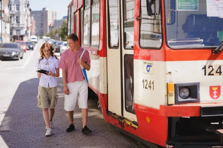 Logistyka i spedycja | Studia I stopnia w Gdyni | Uniwersytet WSB Merito Gdynia: Studenci idą i mijają stary tramwaj