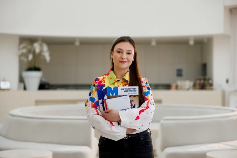 Prompting i optymalizacja systemów AI | Studia I stopnia w Gdyni | Uniwersytet WSB Merito Gdynia: Portret kobiety w kolorowej koszuli w jasnej przestrzeni 