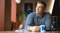Administracja i bezpieczeństwo wewnętrzne | Studia II stopnia ze studiami podyplomowymi w Łodzi | Uniwersytet WSB Merito Łódź: Student pije kawę w trakcie przerwy z kubka Uniwersytetu WSB Merito w Łodzi