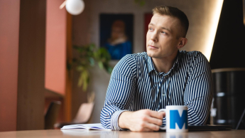 Administracja i bezpieczeństwo wewnętrzne | Studia II stopnia ze studiami podyplomowymi w Łodzi | Uniwersytet WSB Merito Łódź: Student pije kawę w trakcie przerwy z kubka Uniwersytetu WSB Merito w Łodzi