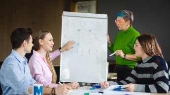 Digital marketing | Studia II stopnia w Łodzi | Uniwersytet WSB Merito Łódź: Czwórka osób analizuje wykres na tablicy.