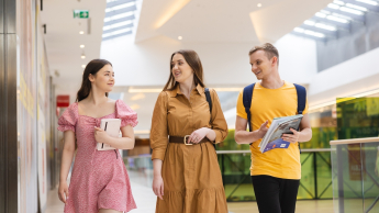 Akademia Startup Management | Studia podyplomowe w Łodzi | Uniwersytet WSB Merito Łódź: Trójka studentów przechadza się po galerii handlowej.