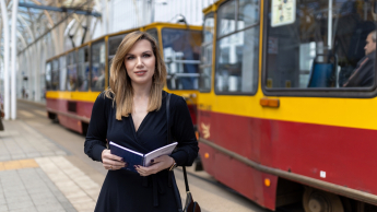 Zarządzanie bezpieczeństwem na kolei | Studia II stopnia ze studiami podyplomowymi  | Uniwersytet WSB Merito Łódź: Studentka Uniwersytetu WSB Merito w Łodzi pozuje do zdjęcia.