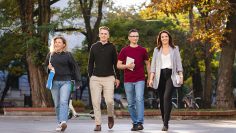 Bezpieczeństwo i higiena pracy | Studia podyplomowe w Łodzi | Uniwersytet WSB Merito Łódź: 4 studentów Uniwersytetu WSB Merito w Łodzi w wesołej atmosferze idzie przez park