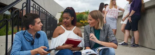 Studia i praktyki za granicą | Uniwersytet WSB Merito Łódź: Grupka studentów siedzi na schodach i rozmawia ze sobą