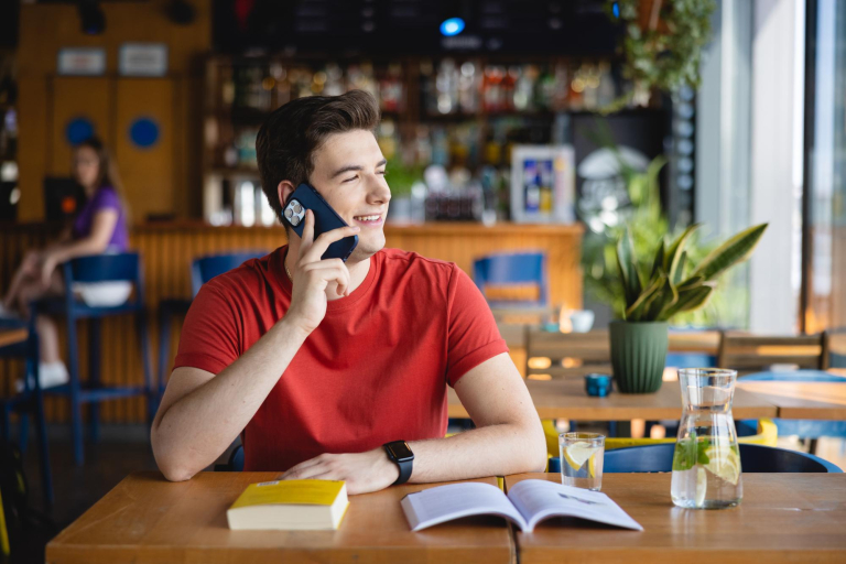 Sztuczna inteligencja w automatyzacji biznesu | Studia podyplomowe w Łodzi | Uniwersytet WSB Merito Łódź: Student Uniwersytetu WSB Merito w Łodzi rozmawia przez telefon.