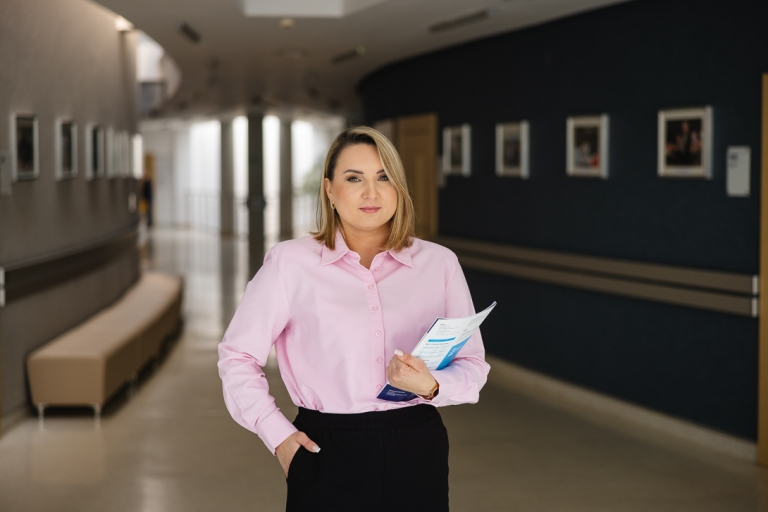 Studia MBA w Łodzi | Uniwersytet WSB Merito Łódź: Uczestniczka MBA Stoi na korytarzu uczelni- Uniwersytet WSB Merito Torun
