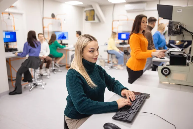 AI w logistyce | Studia I stopnia w Łodzi | Uniwersytet WSB Merito Łódź: Studenci pracują w nowocześnie wyposażonym laboratorium, korzystając z komputerów i specjalistycznych urządzeń do nauki logistyki i technologii informacyjnych.