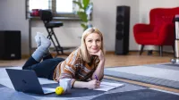 Wyniki wyszukiwania | Uniwersytet WSB Merito Opole: Główna grafika: Opole - specjalność Praca z osobami niedostosowanymi społecznie z profilaktyką uzależnień - kobieta leżąca na dywanie a przed nia komputer 