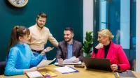 Prawo e-biznesu i sztucznej inteligencji | Studia I stopnia w Opolu | Uniwersytet WSB Merito Opole: Główna grafika: Opole - specjalność Prawo e-biznesu i sztucznej inteligencji - grupa studentów siedząca za stołem, przed komputerem 