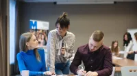 Zarządzanie kryzysowe i pomoc humanitarna | Studia II stopnia w Opolu | Uniwersytet WSB Merito Opole: Główna grafika: Opole - specjalność Administracja bezpieczeństwa publicznego - grupa studentów przeglądających notatki