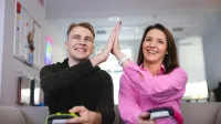 Pedagogika opiekuńczo-wychowawcza z terapią zajęciową | Studia II stopnia ze studiami podyplomowymi  | Uniwersytet WSB Merito Opole: Główna grafika: Opole - studia II stopnia - studenci grający w grę, przybijają piątkę