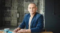 Akademia zarządzania zmianą i strategią | Studia podyplomowe w Opolu | Uniwersytet WSB Merito Opole: Główna grafika: Opole - studia podyplomowe - Mężczyzna siedzący za biurkiem