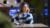 Administracja – prawo, zarządzanie i organizacja | Studia podyplomowe w Opolu | Uniwersytet WSB Merito Opole: Główna grafika: Opole - studia podyplomowe - Administracja – prawo, zarządzanie i organizacja - Kobieta siedząca w kawiarni, trzyma kubek z logotypem Merito