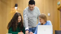 Doradztwo podatkowe | Studia II stopnia w Opolu | Uniwersytet WSB Merito Opole: Główna grafika: Opole - studia II stopnia - specjalność Doradztwo podatkowe - dwie studentki pracujące nad projektem pod okiem wykładowcy