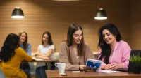 Specjalista kadr i płac | Studia I stopnia w Opolu | Uniwersytet WSB Merito Opole: Główna grafika: Opole - studia I stopnia - specjalność Specjalista kadr i płac -  Grupa osób w kawiarni, na pierwszym planie dwie kobiety przeglądające notatki