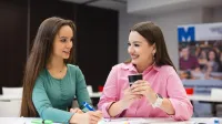 Rachunkowość | Studia I stopnia w Opolu | Uniwersytet WSB Merito Opole: Główna grafika: Opole - studia I stopnia - specjalność Rachunkowość - Dwie dziewczyny spisujące razem notatki