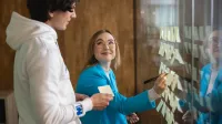 Inżynieria jakości i Lean Manufacturing | Studia I stopnia w Opolu | Uniwersytet WSB Merito Opole: Główna grafika: Opole - studia I stopnia - specjalność Inżynieria jakości i Lean Manufacturing - Dwie osoby tworzące notatki za pomocą karteczek samoprzylepnych