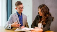 Doradztwo podatkowe | Studia II stopnia w Opolu | Uniwersytet WSB Merito Opole: Główna grafika: Opole - studia II stopnia - specjalność Doradztwo podatkowe -  Dwie osoby przeglądające książkę