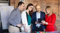 Neuroprzywództwo | Uniwersytet WSB Merito Opole: Główna grafika: Opole - studia podyplomowe - Neuroprzywództwo - Grupa osób patrząca w ekran tabletu