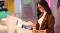 Sztuczna inteligencja i Data Science | Studia I stopnia w Opolu | Uniwersytet WSB Merito Opole: Główna grafika: Opole - studia I stopnia inżynierskie- Informatyka: Sztuczna inteligencja i Data Science -studentka stoi przy tablecie multimedialnym i analizuje treści