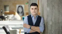 Zarządzanie i automatyzacja procesów w biznesie | Studia podyplomowe w Opolu | Uniwersytet WSB Merito Opole: Główna grafika: Opole - studia podyplomowe -Zarządzanie i automatyzacja procesów w biznesie- uczestnik studiów podyplomowych stoi oparty o ścianę z założonymi rękami