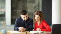 E-commerce i zarządzanie platformami sprzedażowymi | Uniwersytet WSB Merito Opole: Główna grafika: Opole - studia podyplomowe - E-commerce i zarządzanie platformami sprzedażowymi- uczestnicy studiów podyplomowych siedzą przy biurku i analizują treści z notatnika