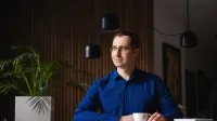 E-commerce i zarządzanie platformami sprzedażowymi | Uniwersytet WSB Merito Opole: Główna grafika: Opole - studia podyplomowe - E-commerce i zarządzanie platformami sprzedażowymi- uczestnik studiów podyplomowych siedzi przy biurku z filiżanką w ręce i spogląda za okno
