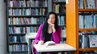 Warsztat pracy pedagoga-wychowawcy | Studia podyplomowe w Opolu | Uniwersytet WSB Merito Opole: Główna grafika: Opole - studia podyplomowe -Warsztat pracy pedagoga-wychowawcy- uczestniczka studiów podyplomowych siedzi przy stoliku i robi notatki