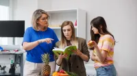 Psychodietetyka i terapia zaburzeń odżywiania | Studia II stopnia w Opolu | Uniwersytet WSB Merito Opole: Główna grafika: Opole - studia II stopnia- Dietetyka: Psychodietetyka i terapia zaburzeń odżywiania- studentki analizują książkę w laboratorium dietetycznym