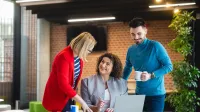 Wycena nieruchomości | Studia podyplomowe w Opolu | Uniwersytet WSB Merito Opole: Główna grafika: Opole - studia podyplomowe - Wycena nieruchomości - uczestnicy studiów podyplomowych rozmawiają wspólnie, analizując tresci z laptopa