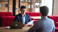 Wycena nieruchomości | Studia podyplomowe w Opolu | Uniwersytet WSB Merito Opole: Główna grafika: Opole - studia podyplomowe - Wycena nieruchomości - uczestnicy studiów podyplomowych rozmawiają wspólnie siedząc na przeciwko siebie