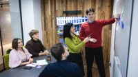 Copywriting sprzedażowy z AI | Studia podyplomowe w Opolu | Uniwersytet WSB Merito Opole: Główna grafika: Opole - studia podyplomowe - Copywriting sprzedażowy z AI - uczestnicy studiów podyplomowych analizują treści z tablicy 