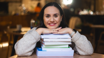 Pedagogika opiekuńczo-wychowawcza z neuropedagogiką | Studia I stopnia w Opolu | Uniwersytet WSB Merito Opole: Młoda dziewczyna opiera ręce na książkach