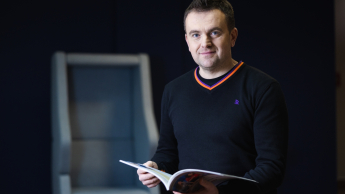 Marketing cyfrowy i grafika reklamowa | Studia I stopnia w Opolu | Uniwersytet WSB Merito Opole: Główna grafika: Opole - specjalność Marketing cyfrowy i grafika reklamowa - mężczyzna w średnim wieku z książką w dłoni