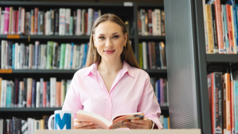 Marketing cyfrowy i grafika reklamowa | Studia I stopnia w Opolu | Uniwersytet WSB Merito Opole: Główna grafika: Opole - specjalność Marketing cyfrowy i grafika reklamowa - studentka w bibliotece