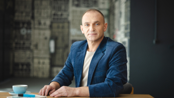 Akademia zarządzania zmianą i strategią | Studia podyplomowe w Opolu | Uniwersytet WSB Merito Opole: Główna grafika: Opole - studia podyplomowe - Mężczyzna siedzący za biurkiem