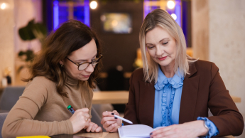 Zarządzanie w oświacie | Studia podyplomowe w Opolu | Uniwersytet WSB Merito Opole: Główna grafika: Opole - studia podyplomowe - Zarządzanie w oświacie - Dwie kobiety przeglądające notatki